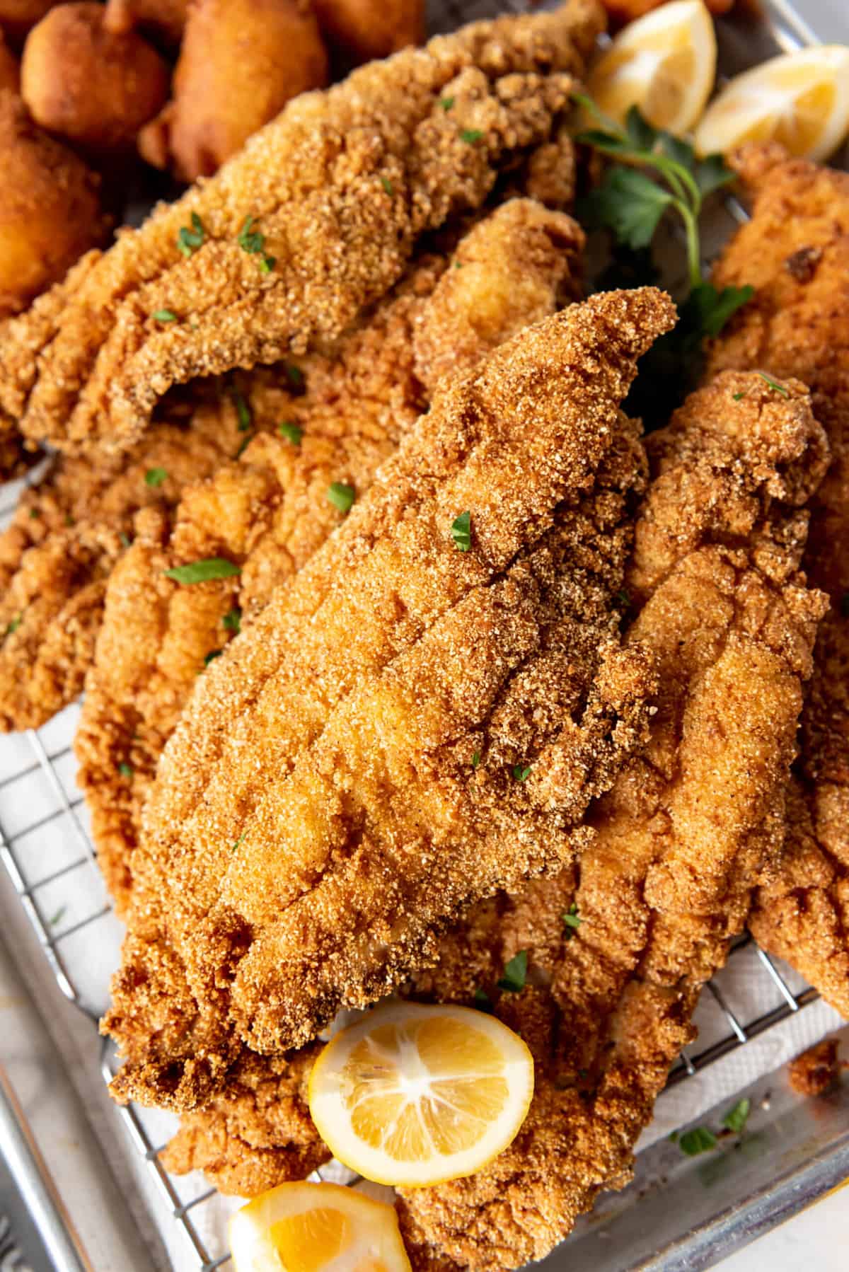 A close image of pieces of fried catfish with cornmeal coating.