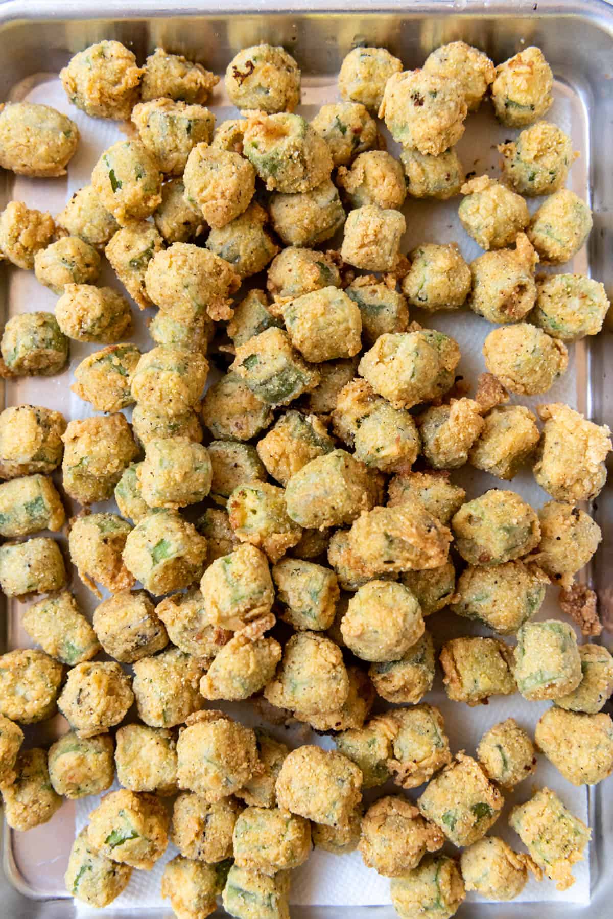A close image of fried okra draining on paper towels.