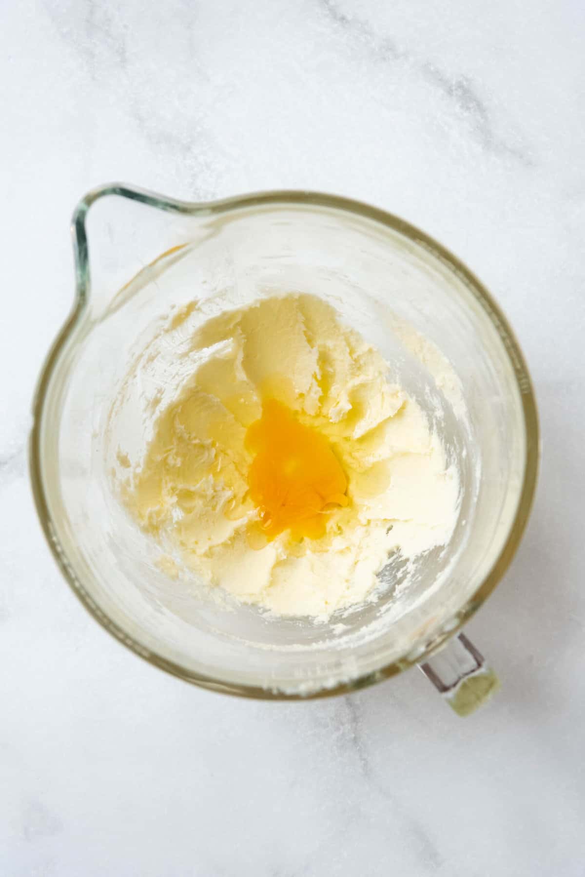 Creamed butter and sugar with two eggs in a mixing bowl.