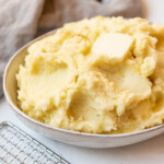 A bowl of mashed potatoes with a pat of butter melting on top.