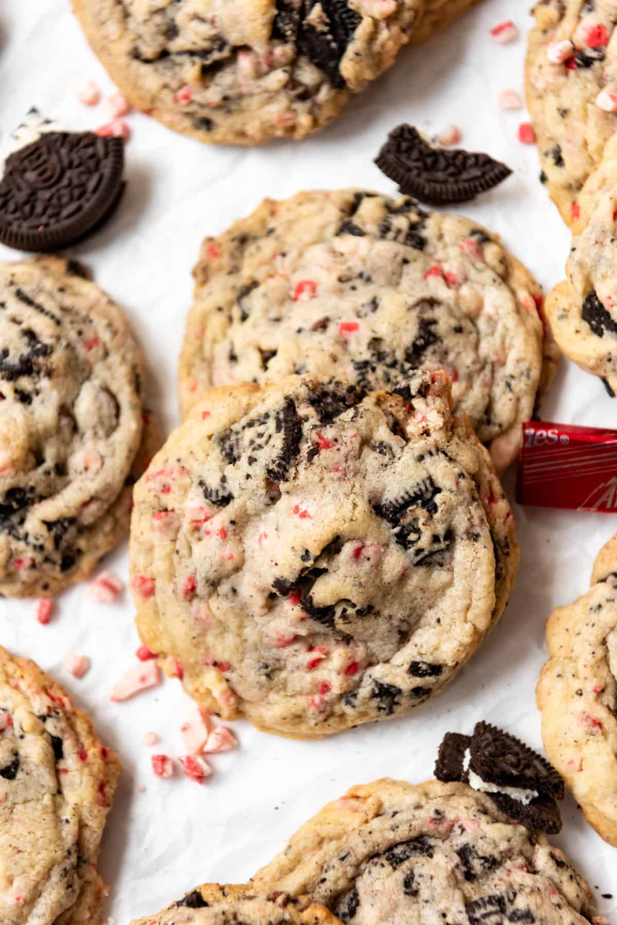 Oreo peppermint cookies overlapping each other with scattered peppermint candy around them.
