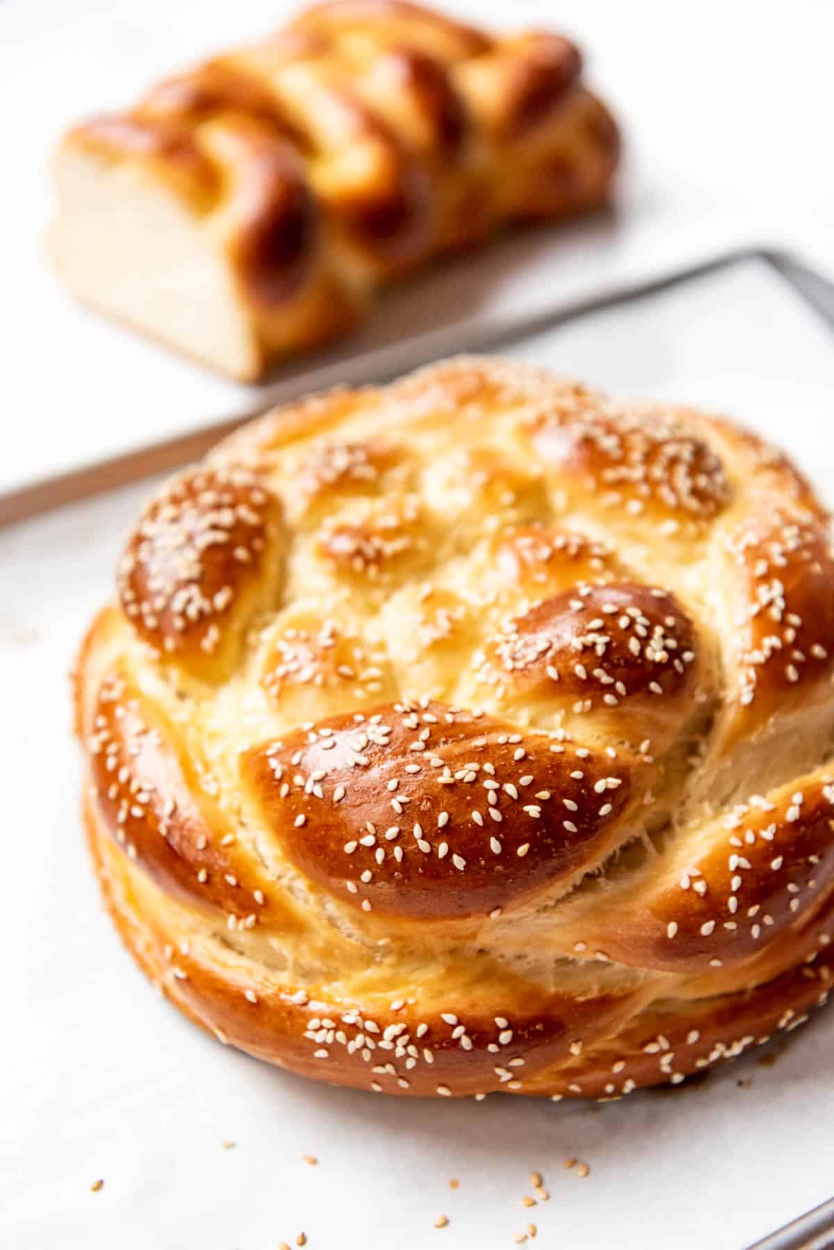 A round braided challah braid with sesame seeds on top.