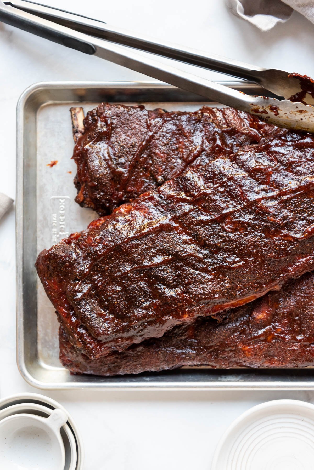 Racks of barbecue ribs on a baking sheet.