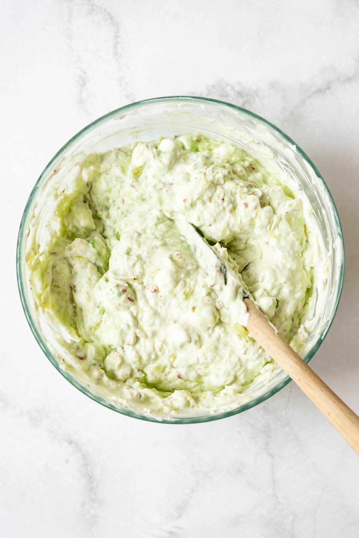 A bowl of watergate salad with a spatula in it.