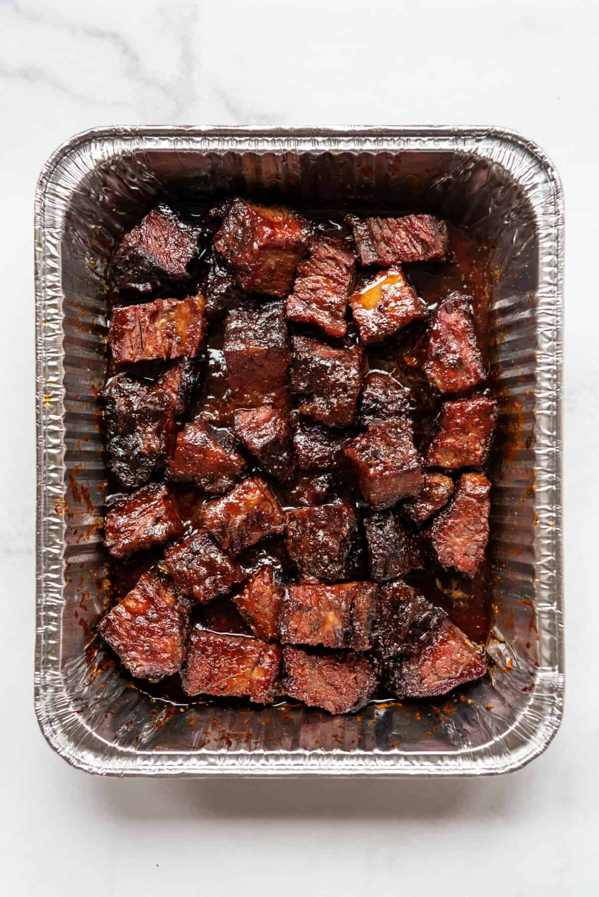 Finished brisket burnt ends in an aluminum pan.