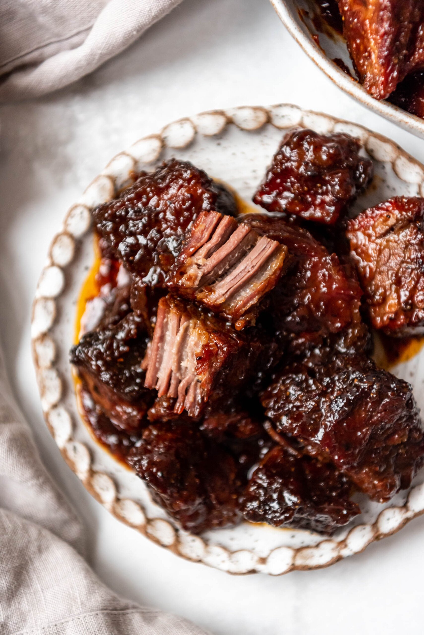 Brisket burnt ends on a plate with one torn in half.
