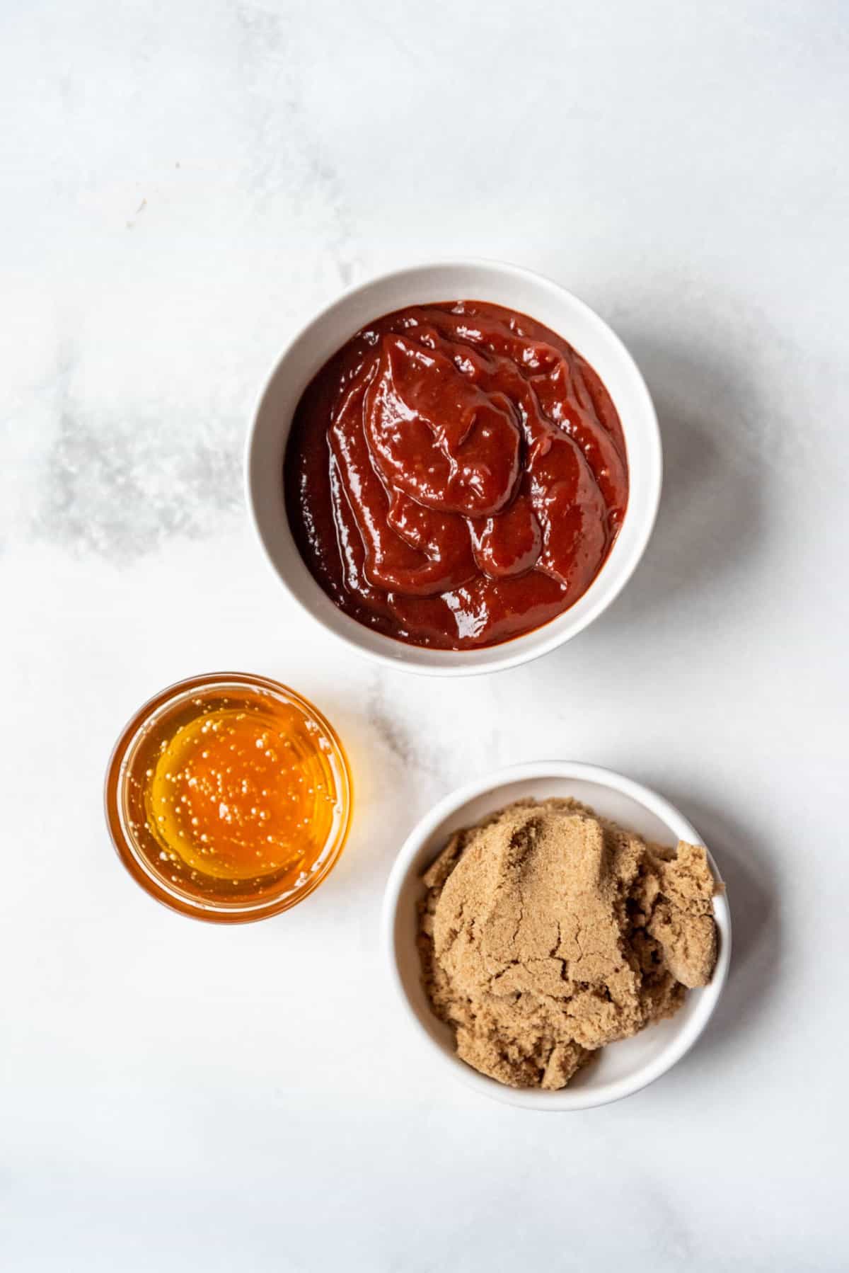 BBQ sauce, honey, and brown sugar in separate bowls.