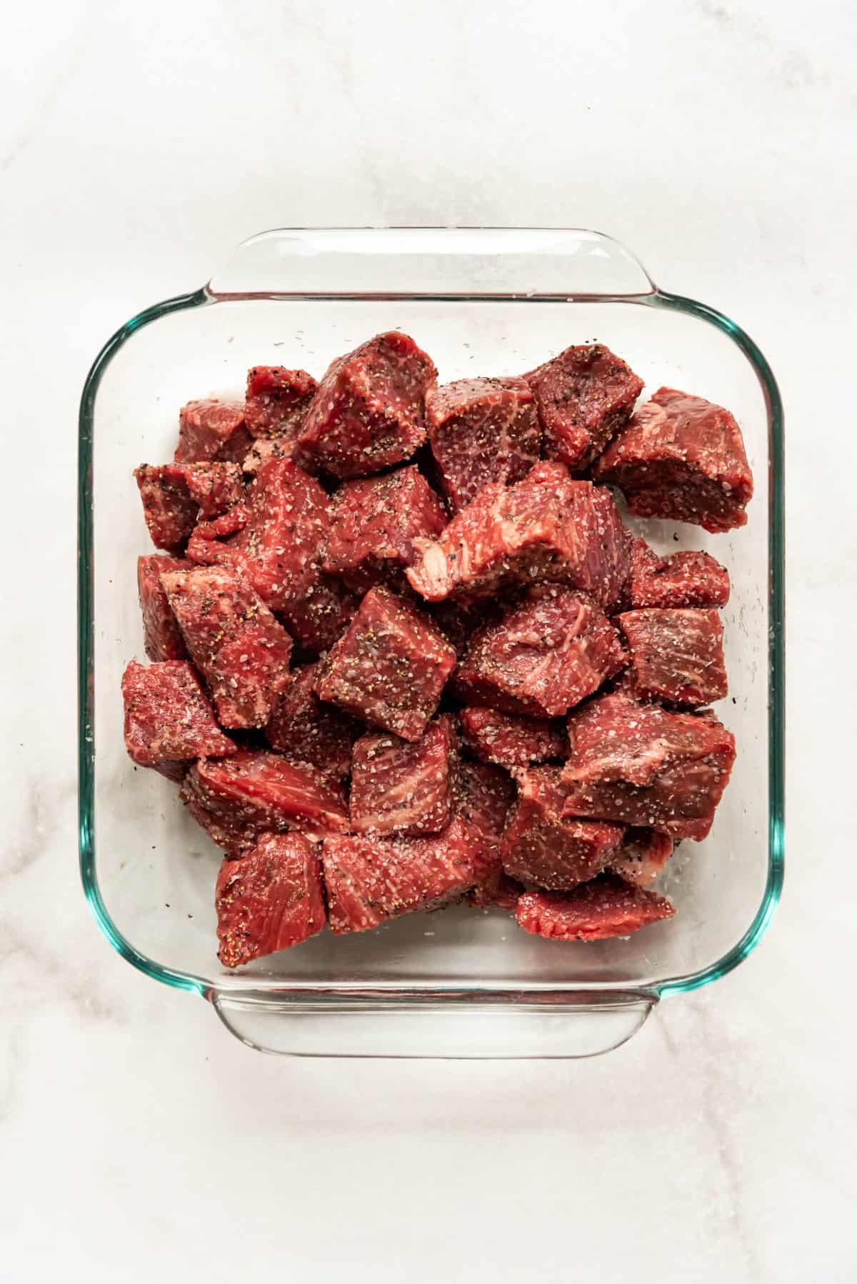 Beef stew meat seasoned with kosher salt and freshly ground black pepper.