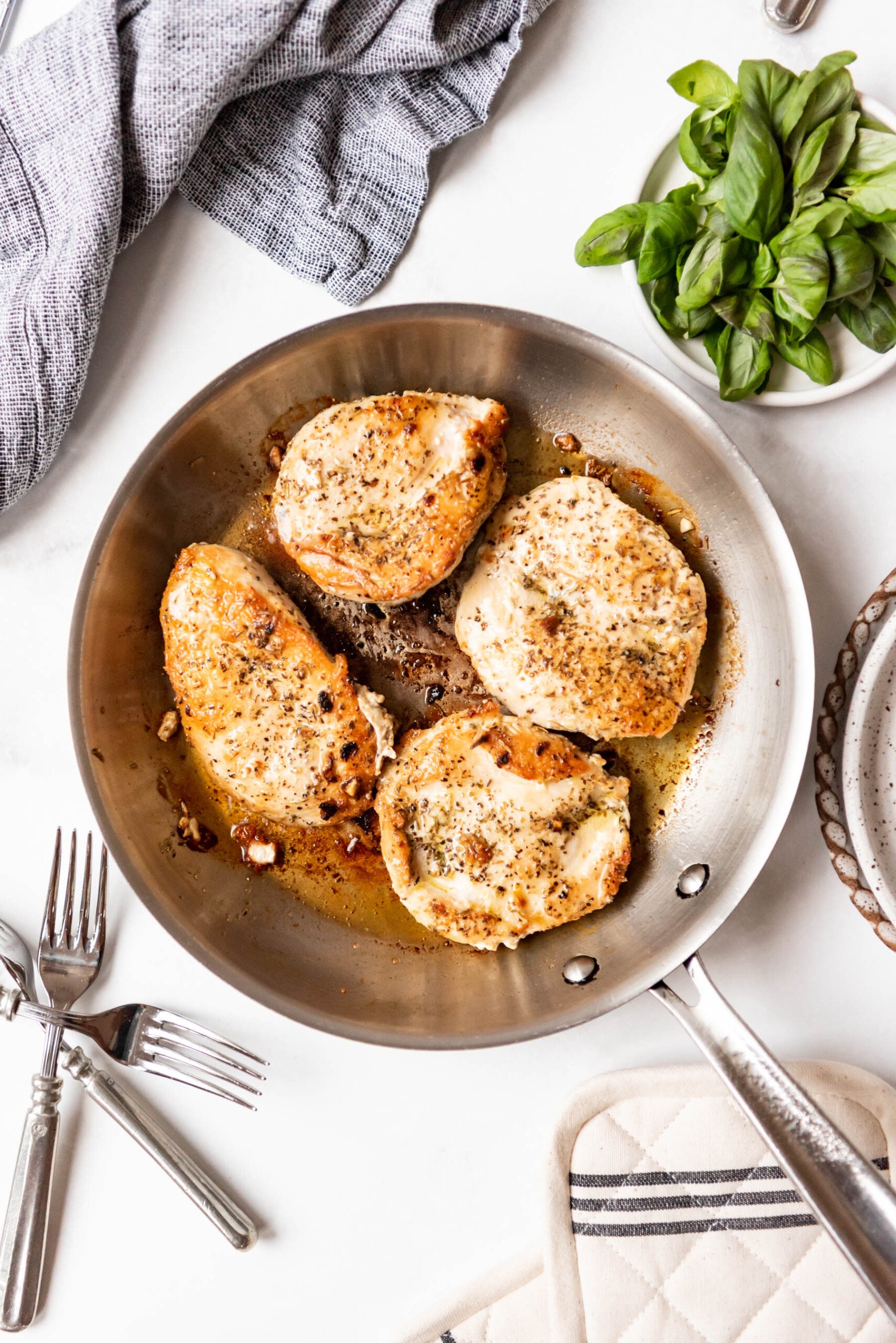 Seared chicken breasts in a pan.