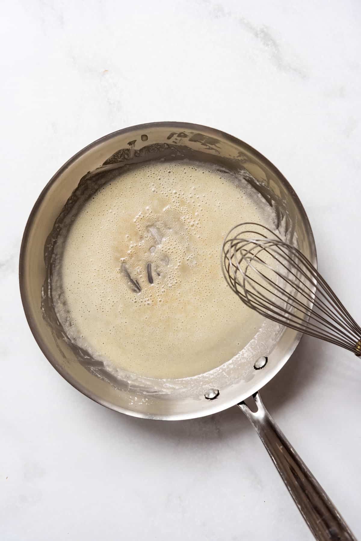 Adding chicken broth to flour and butter in a pan.