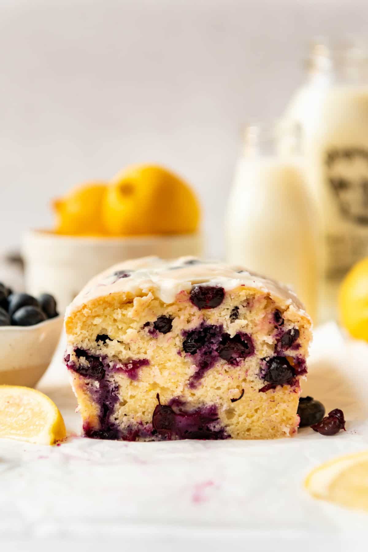 A cross-section of lemon blueberry bread with glaze on top.