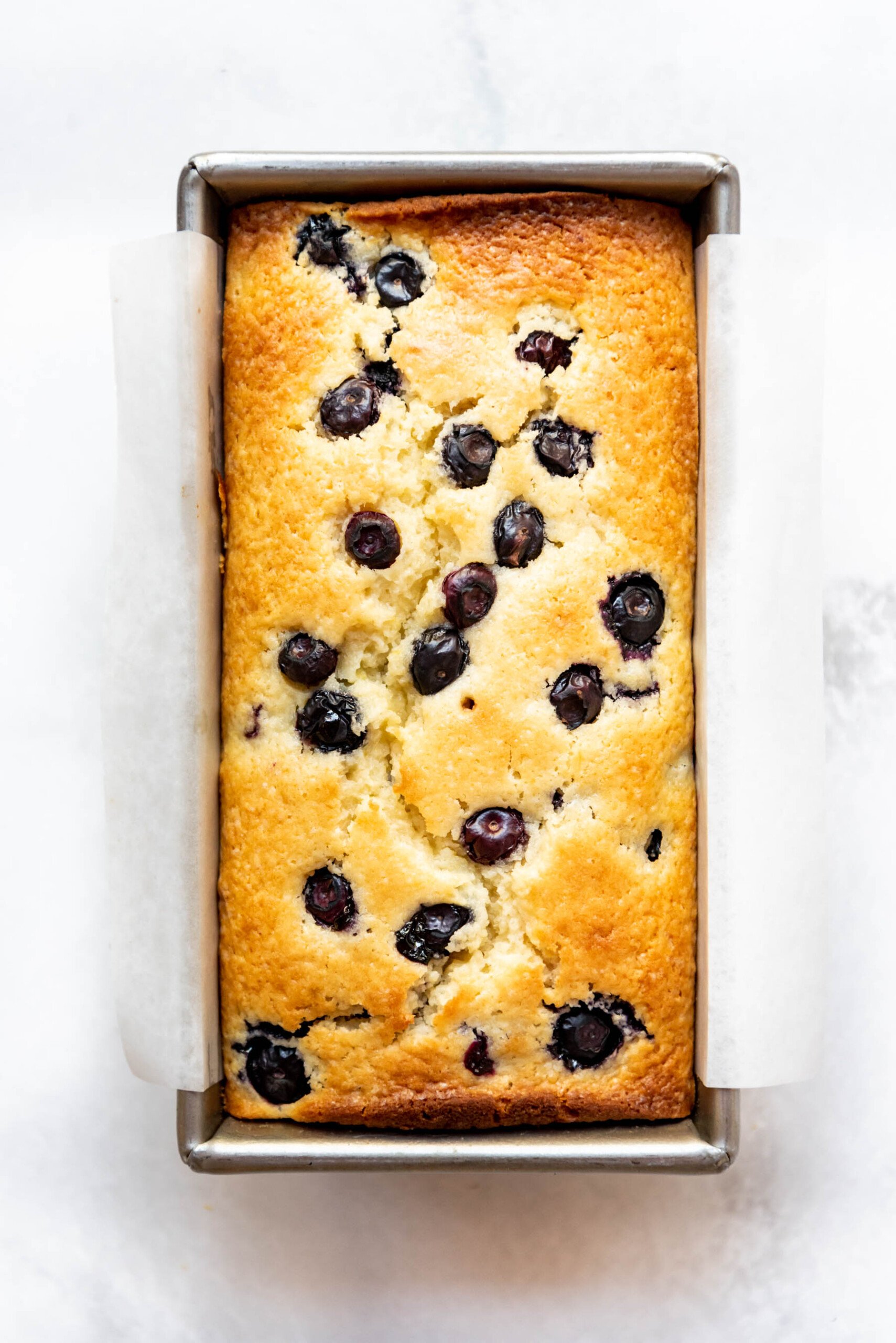 Lemon blueberry quick bread baked in a loaf pan.