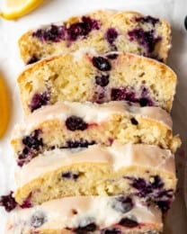 An overhead image of sliced fresh lemon and blueberry bread next to sliced lemons.