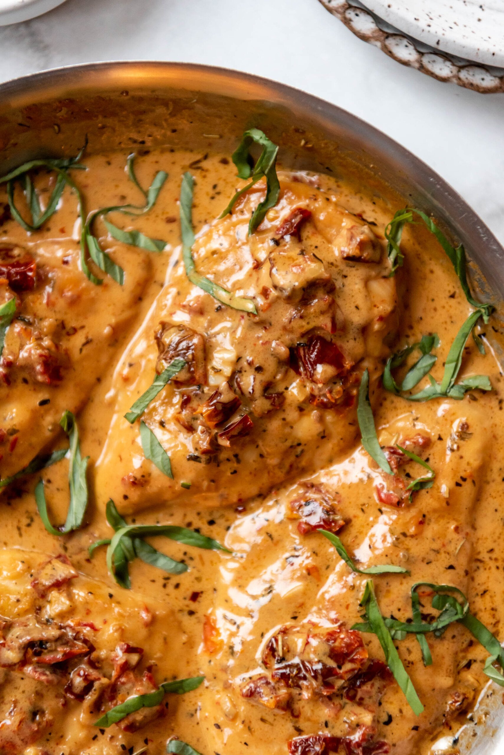 A pan of marry me chicken with a creamy sauce.