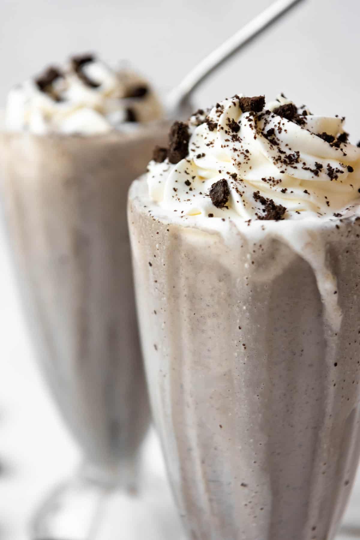 A close image of an Oreo milkshake in an old-fashioned glass.