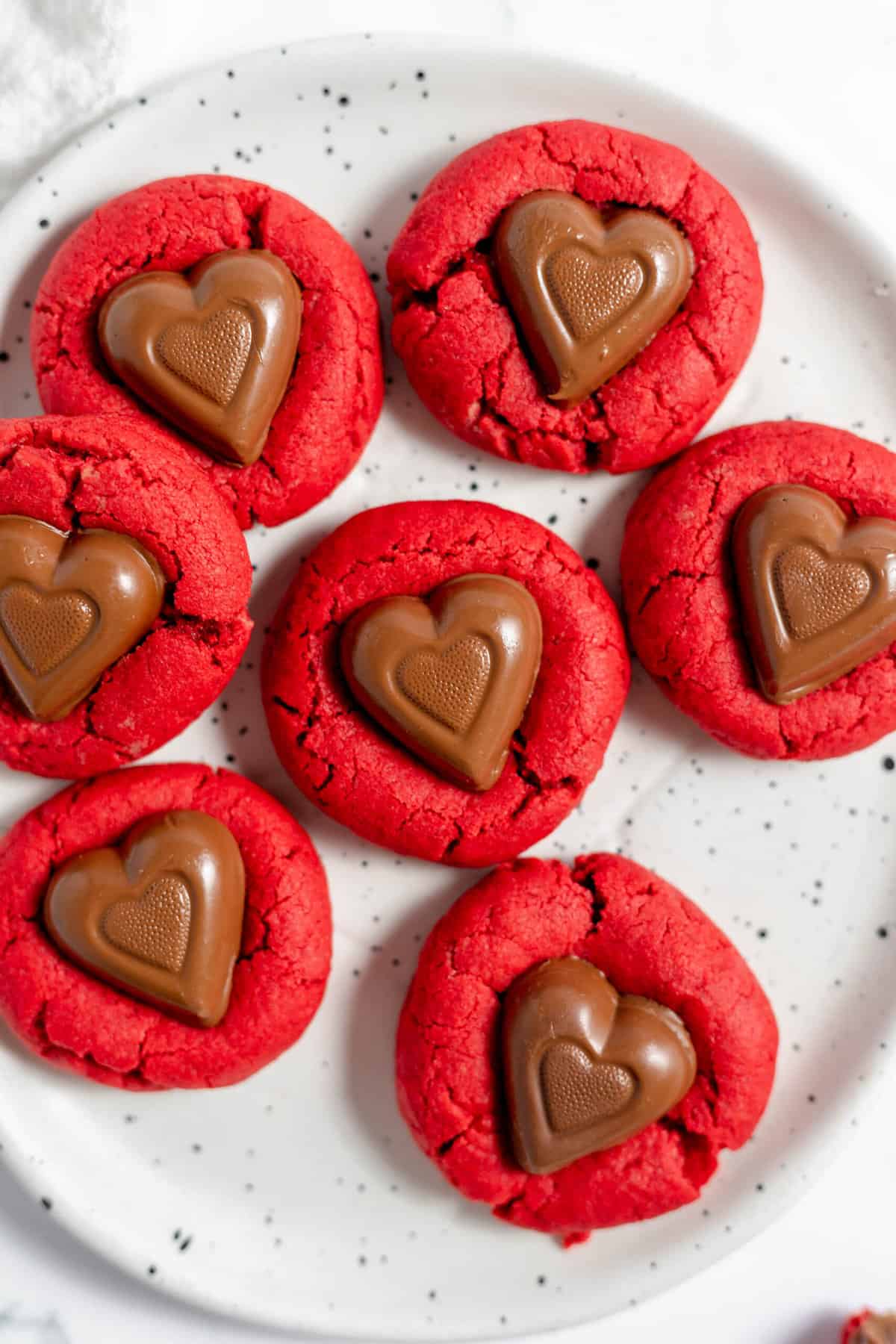 An overhead image of red velvet sweethearts cookies on a plate.