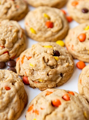 Thick Reese's Pieces cookies on a white surface.