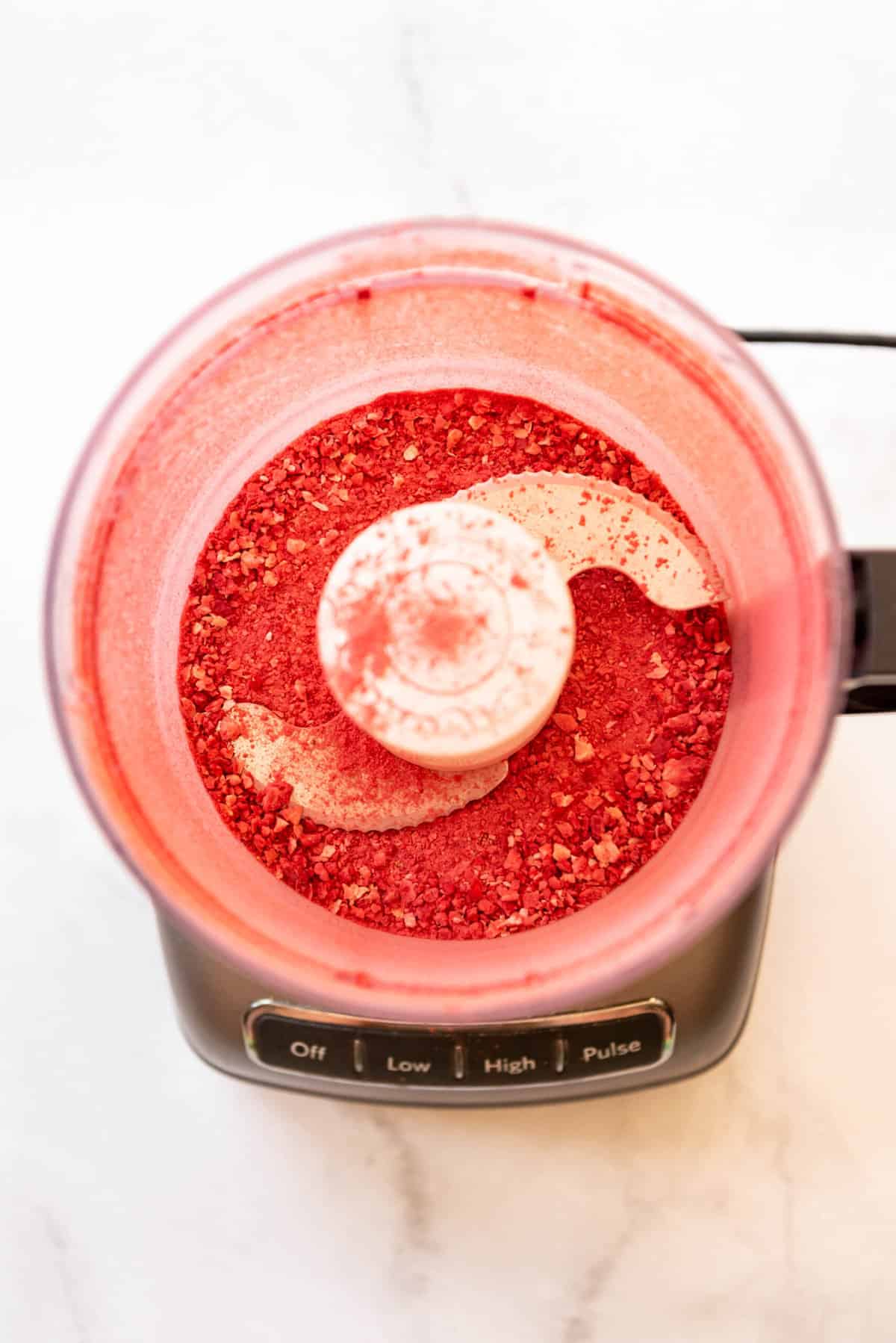 Top view of food processor with powdered freeze-dried strawberries in it. 