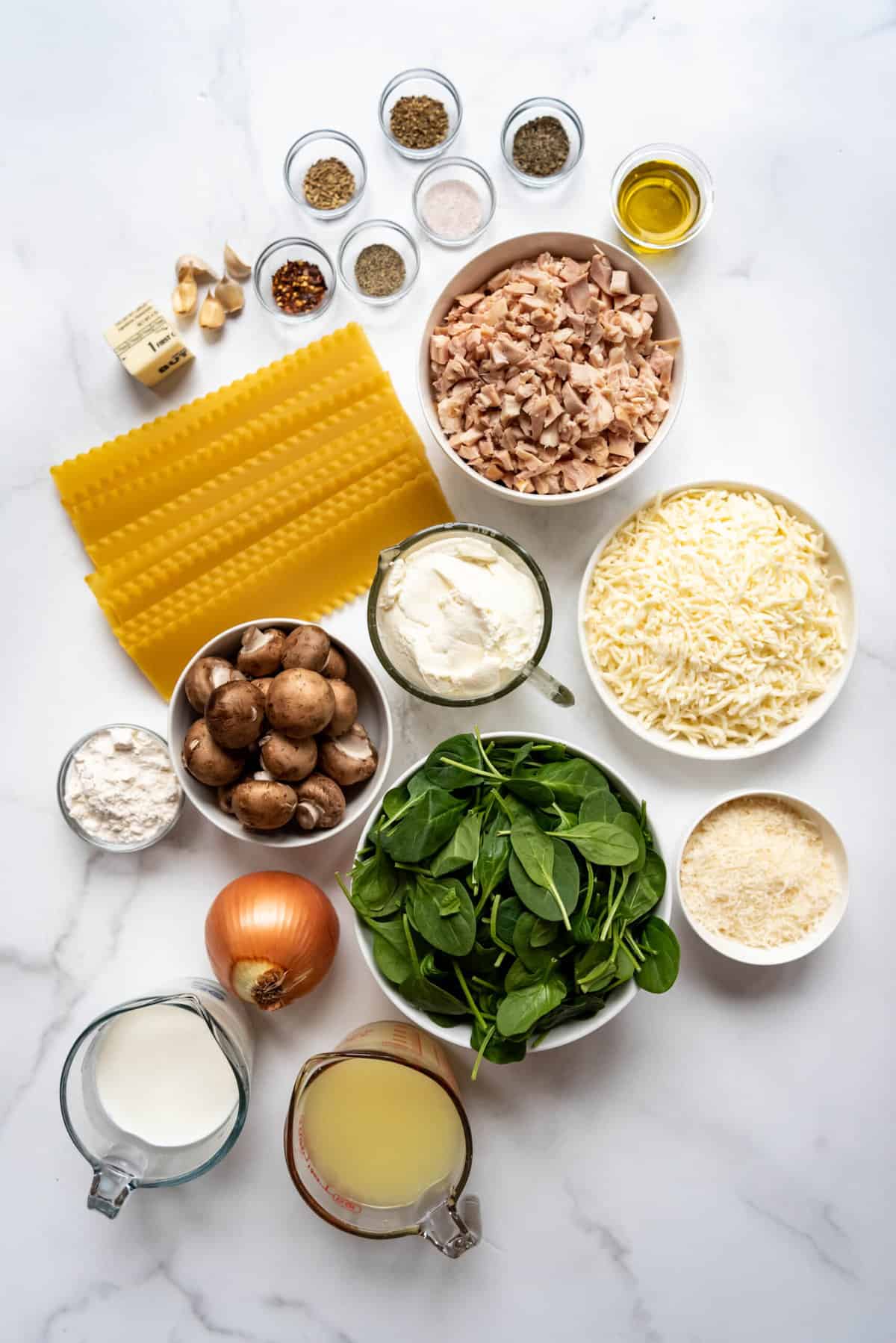 Ingredients for making white chicken lasagna with spinach and mushrooms.
