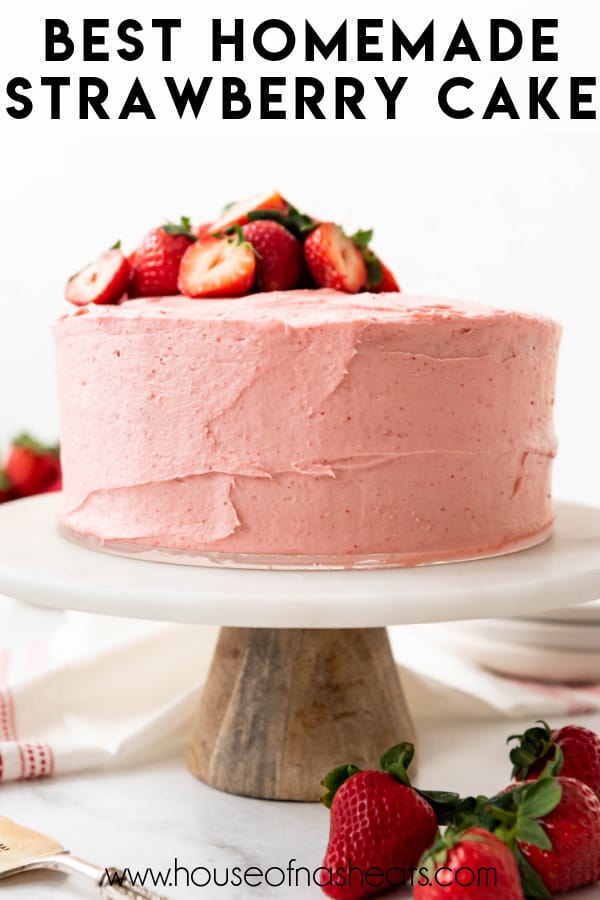 A strawberry layer cake on a cake stand with text overlay.