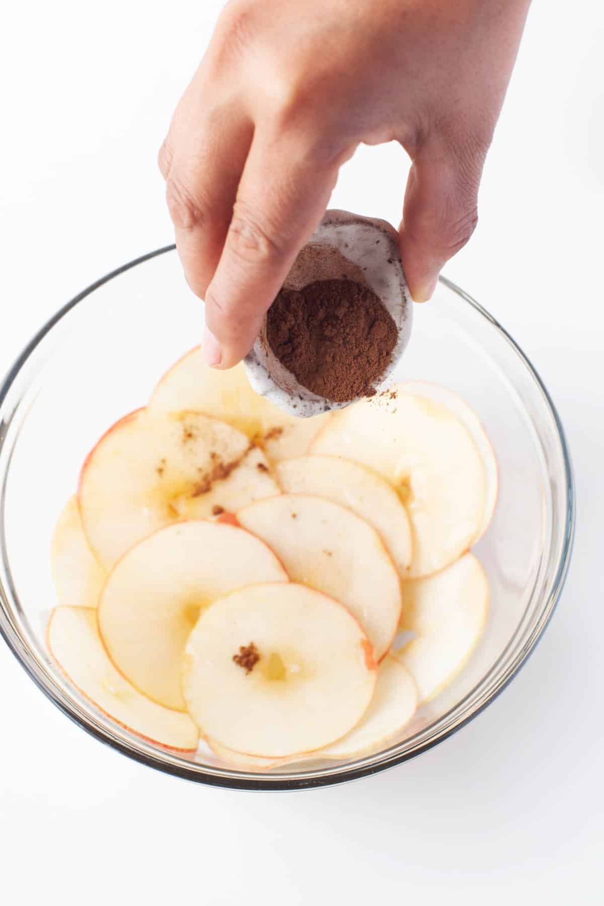 Sprinkling thinly sliced apples with ground cinnamon and nutmeg.
