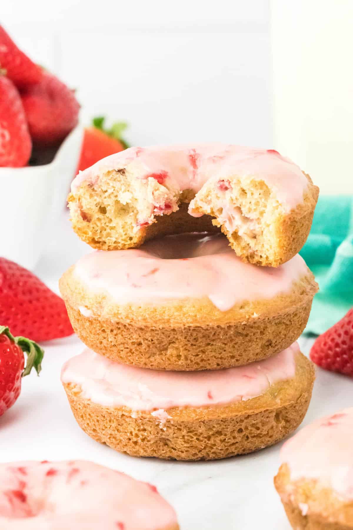 Close up of a stack of strawberry donuts. 