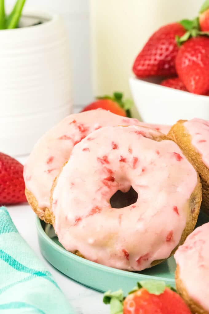 Close up of a strawberry donut on a plate. 