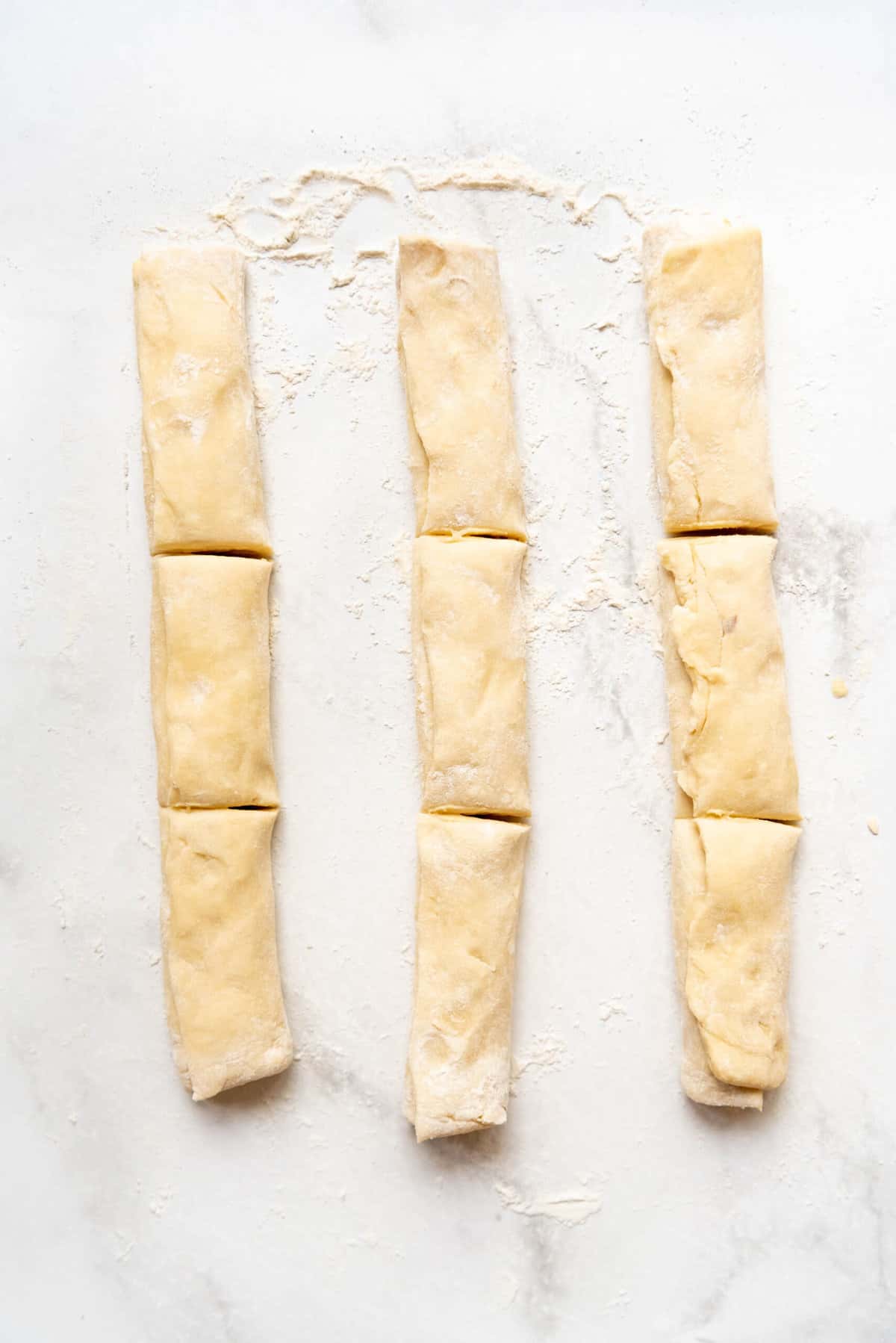 Three rows of bear claw dough cut into thirds.