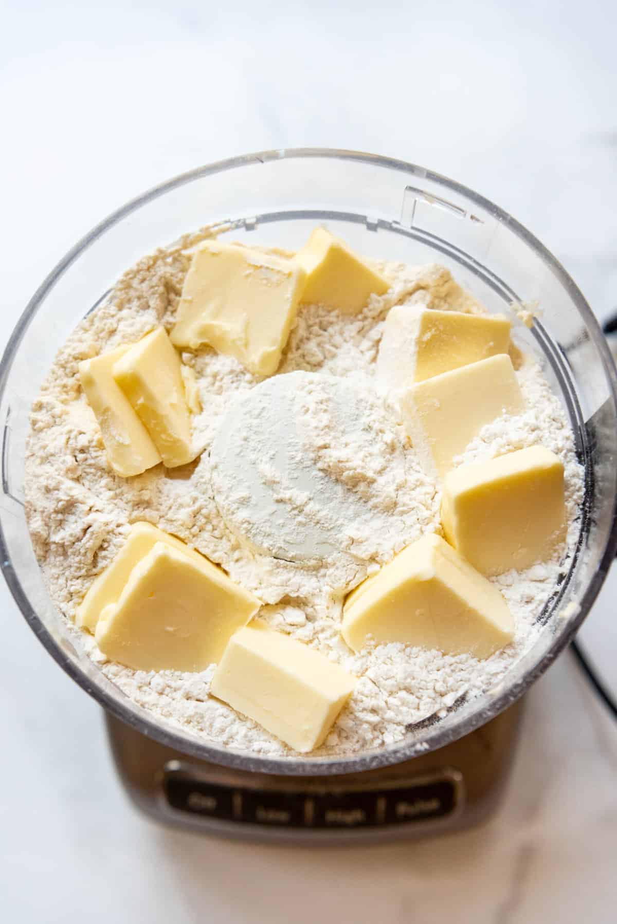 Pulsing butter and flour in a food  processor until it resembles coarse crumbs.