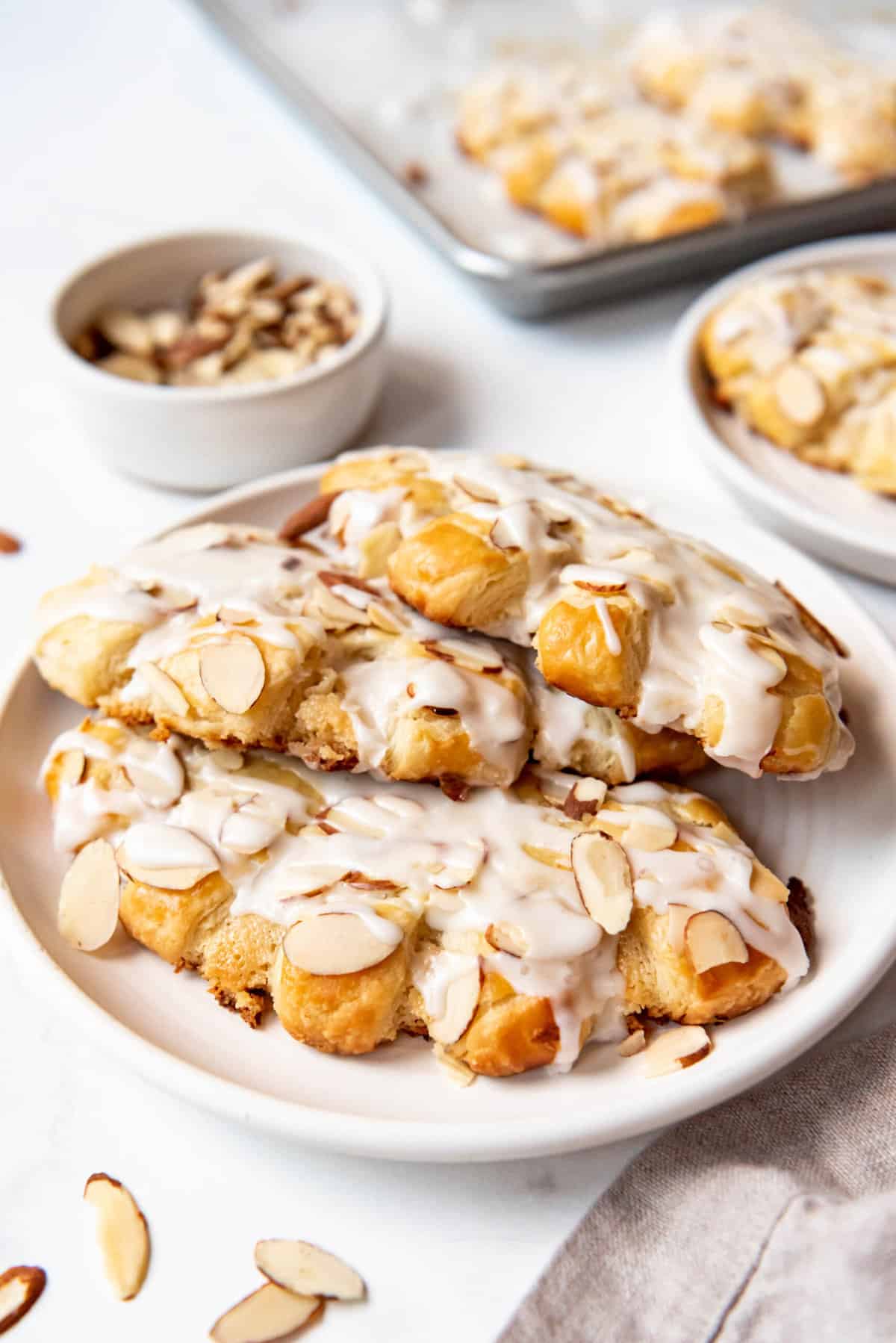 Three almond bear claws on a white plate.