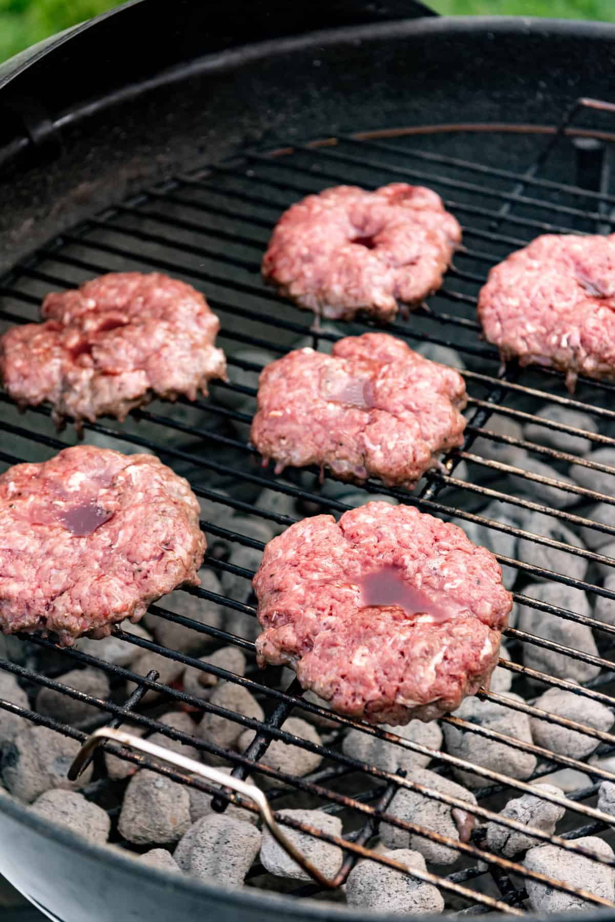 Grilling bison burgers over hot charcoals.