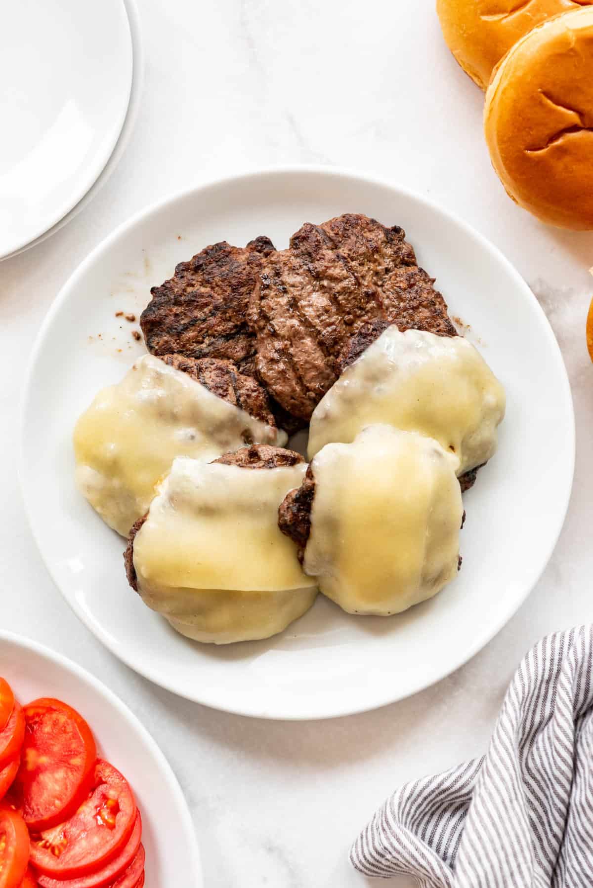 Bison burgers and bison cheeseburgers on a white plate.