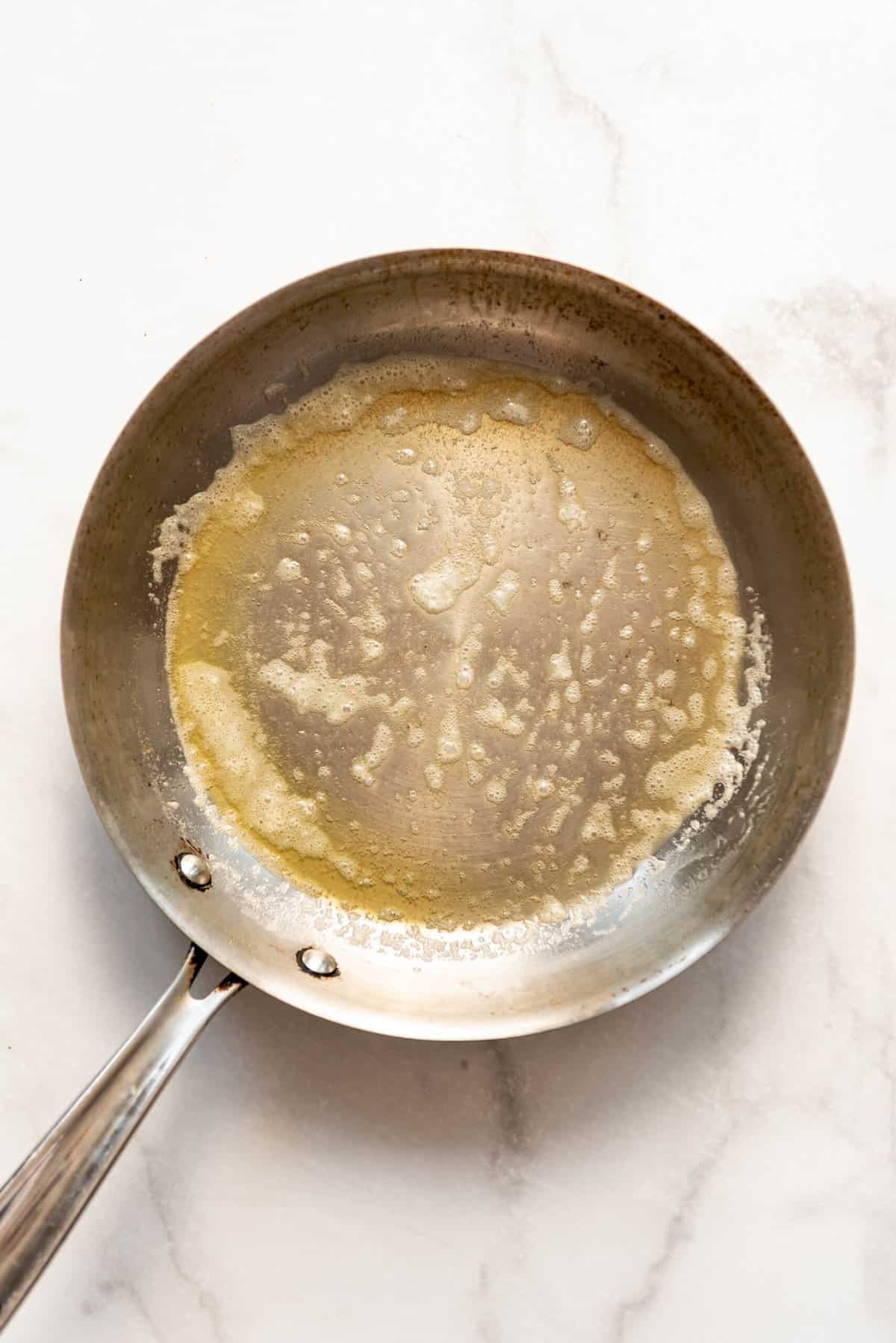 Melting butter in a large skillet.