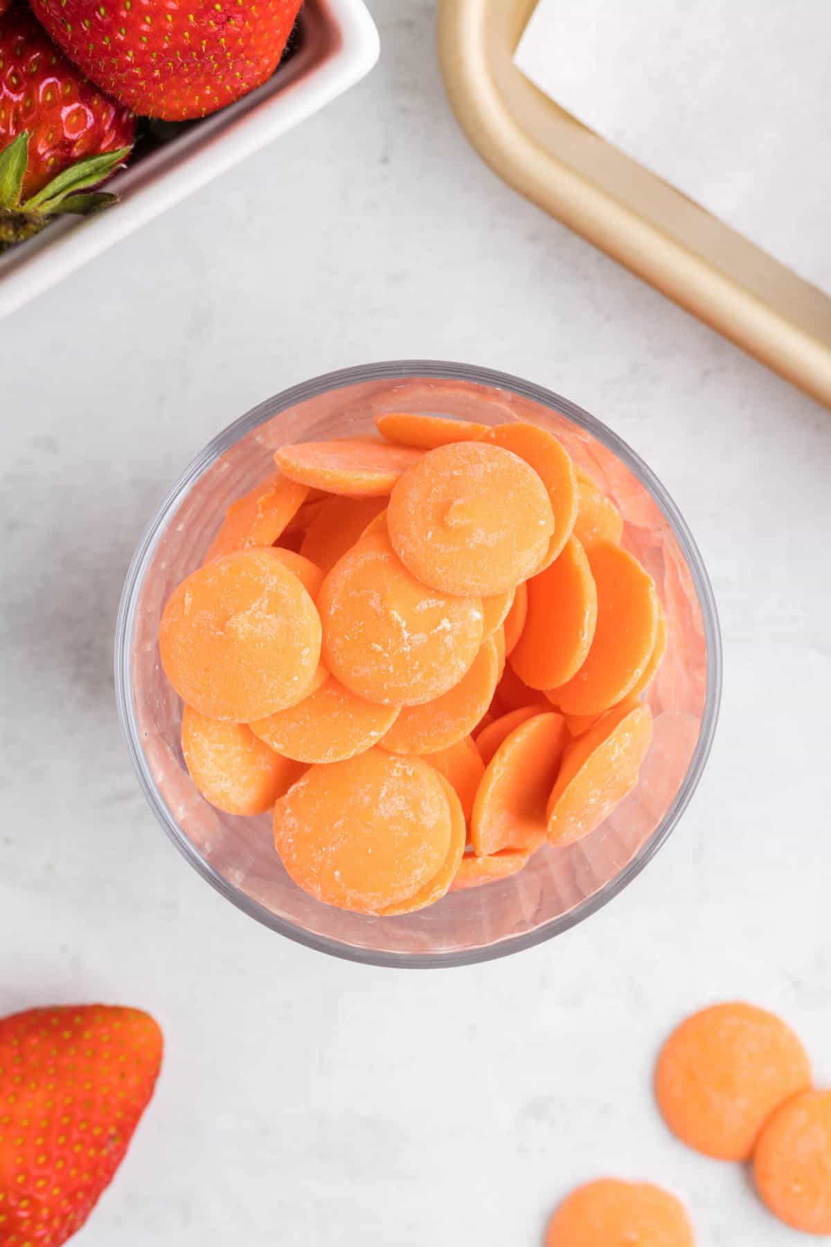 Orange candy melts in a glass bowl.