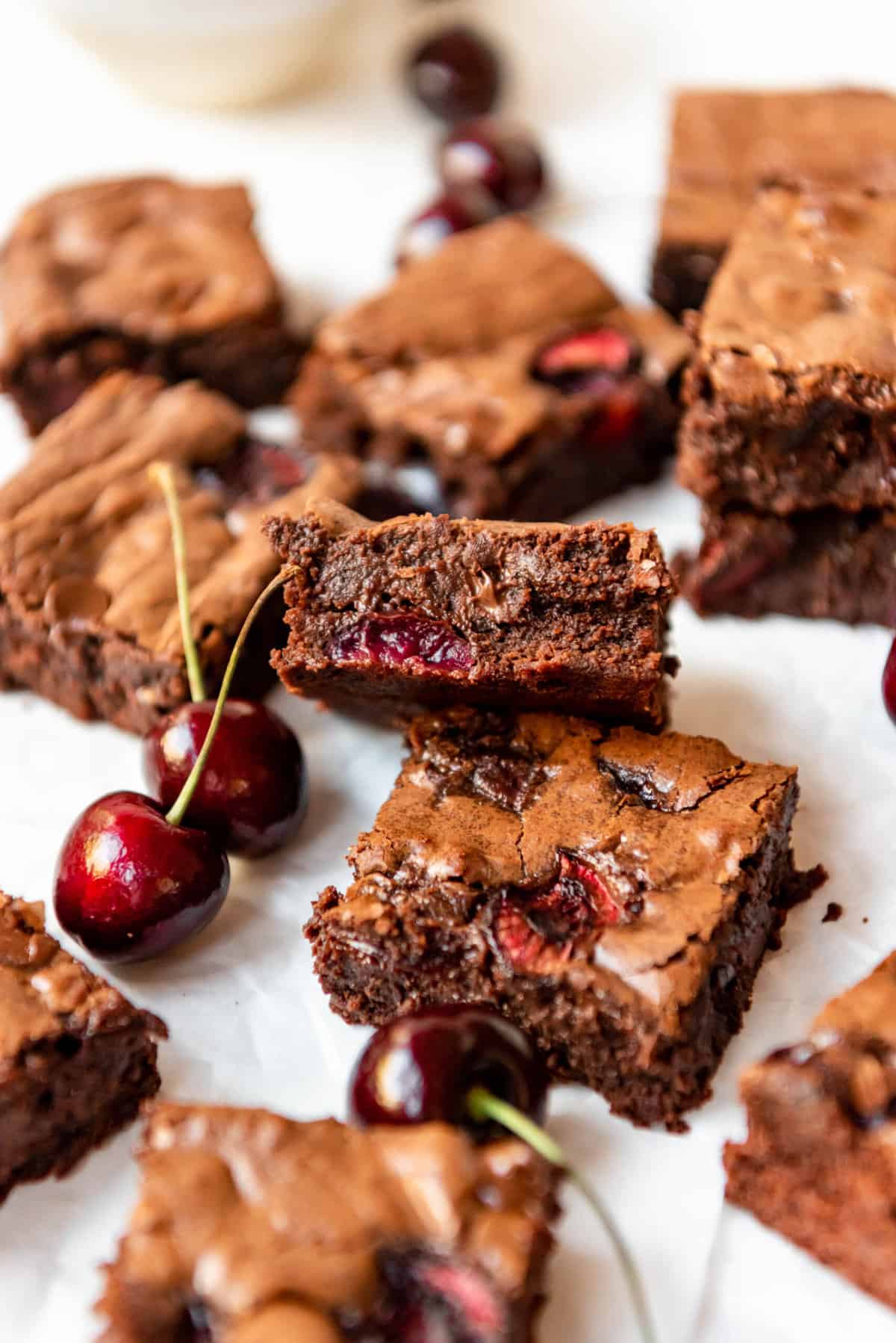 An image of cherry brownies next to fresh cherries.
