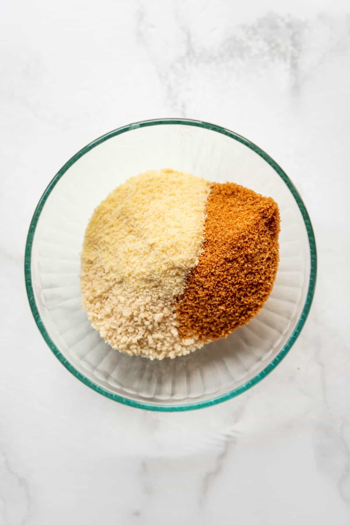 Combining Panko breadcrumbs, powdered Parmesan cheese, and Shake & Bake in a large bowl.