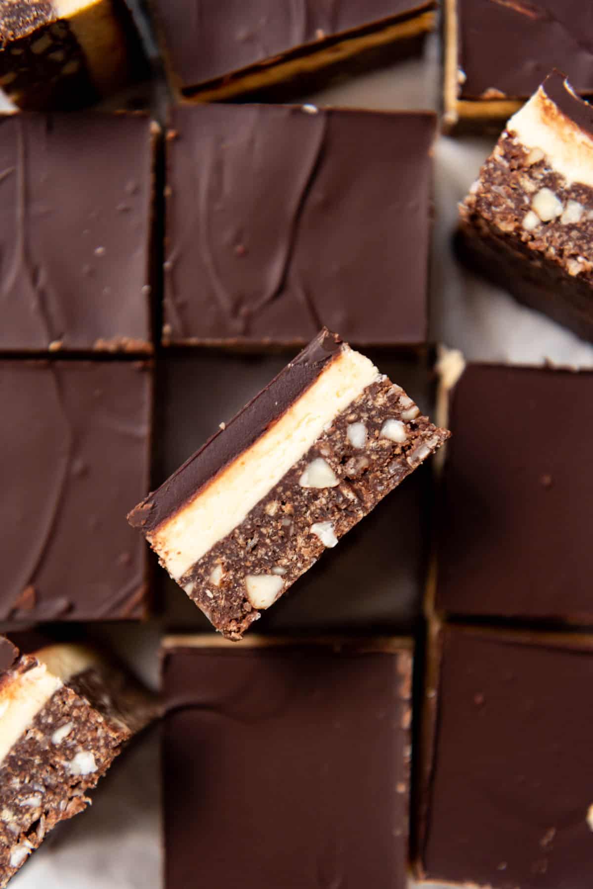 A close image of a nanaimo bar turned on its side to show the layers.
