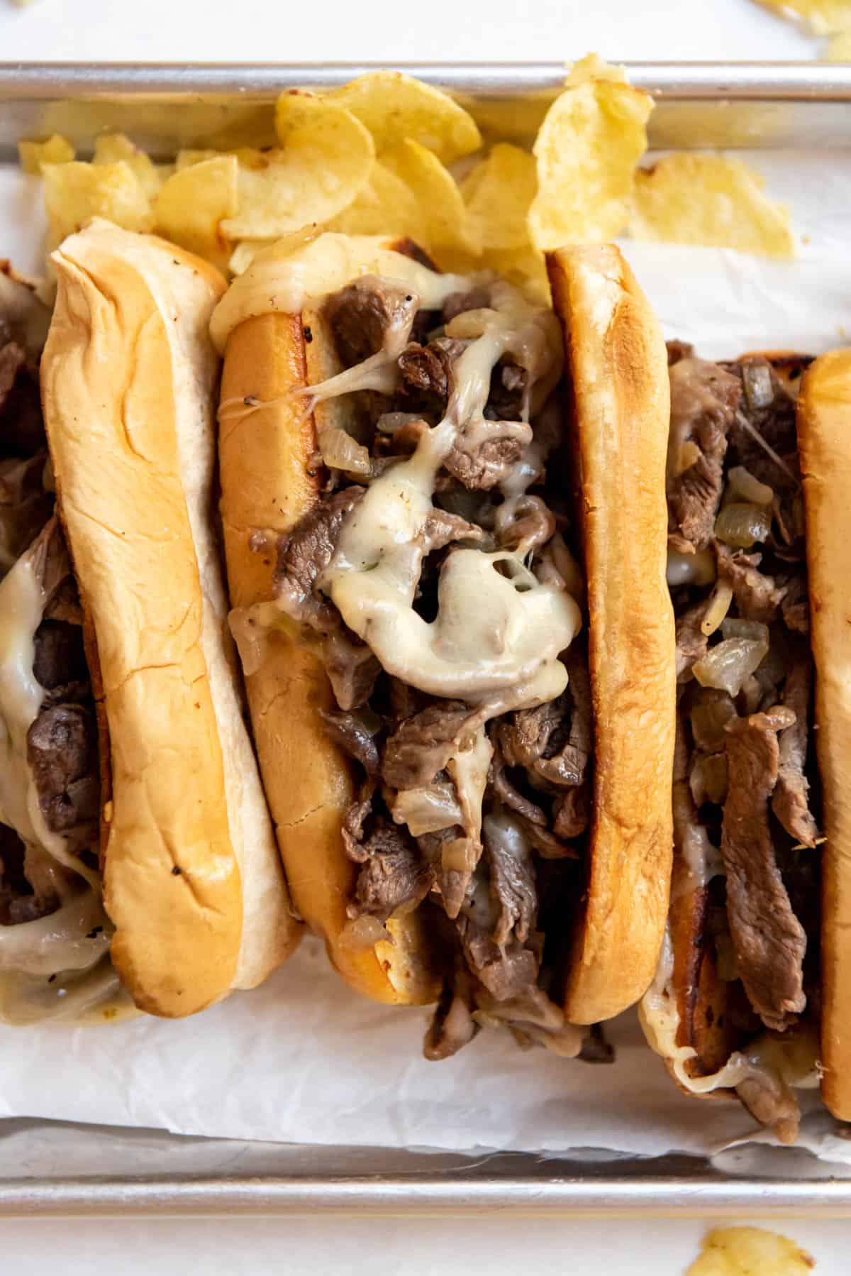 Melted cheese on hot Philly cheese steaks.