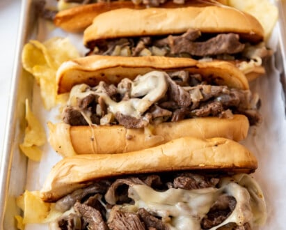 A baking sheet filled with Philly cheese steaks.