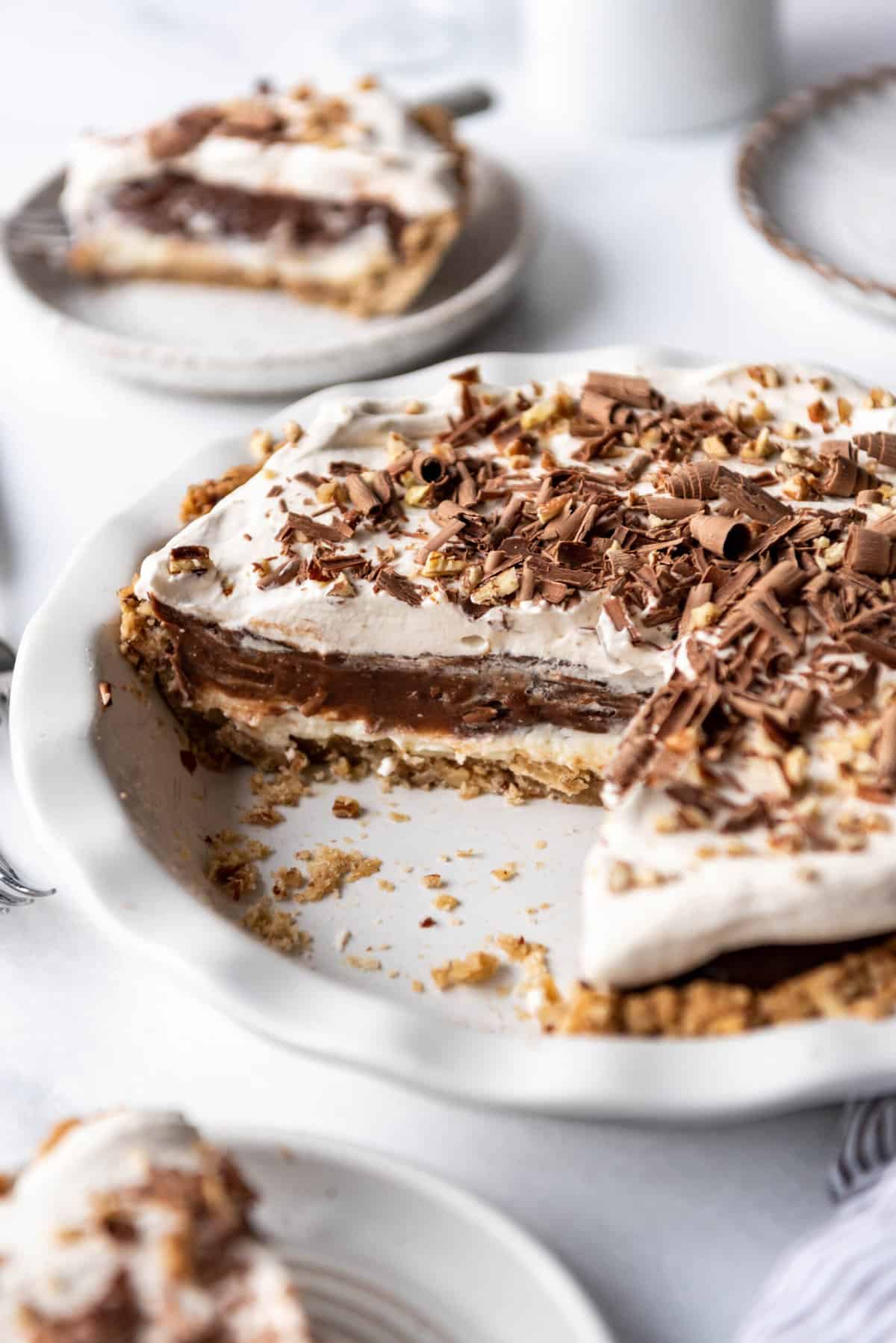 An image of a four-layer delight dessert from Arkansas known as Possum Pie with chocolate shavings and chopped pecans on top.