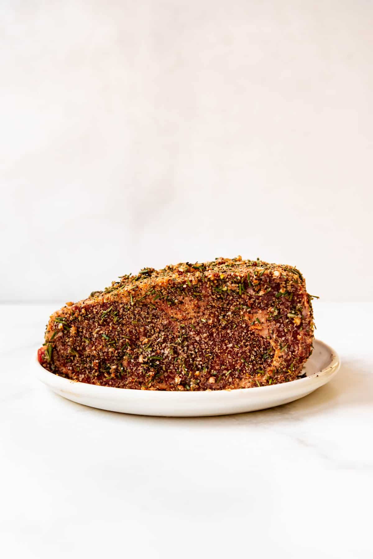 Prime rib roast that has been rubbed with kosher salt, pepper, herbs, and spices.