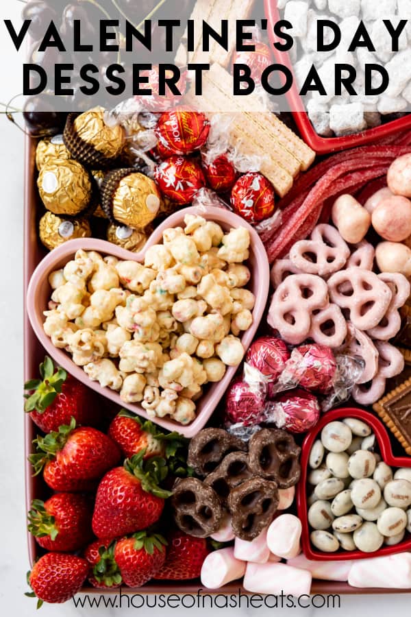 A Valentine's Day dessert board with popcorn, strawberries, and chocolate covered pretzels with text overlay.