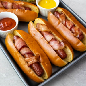 Air Fryer bacon wrapped hot dogs in buns.
