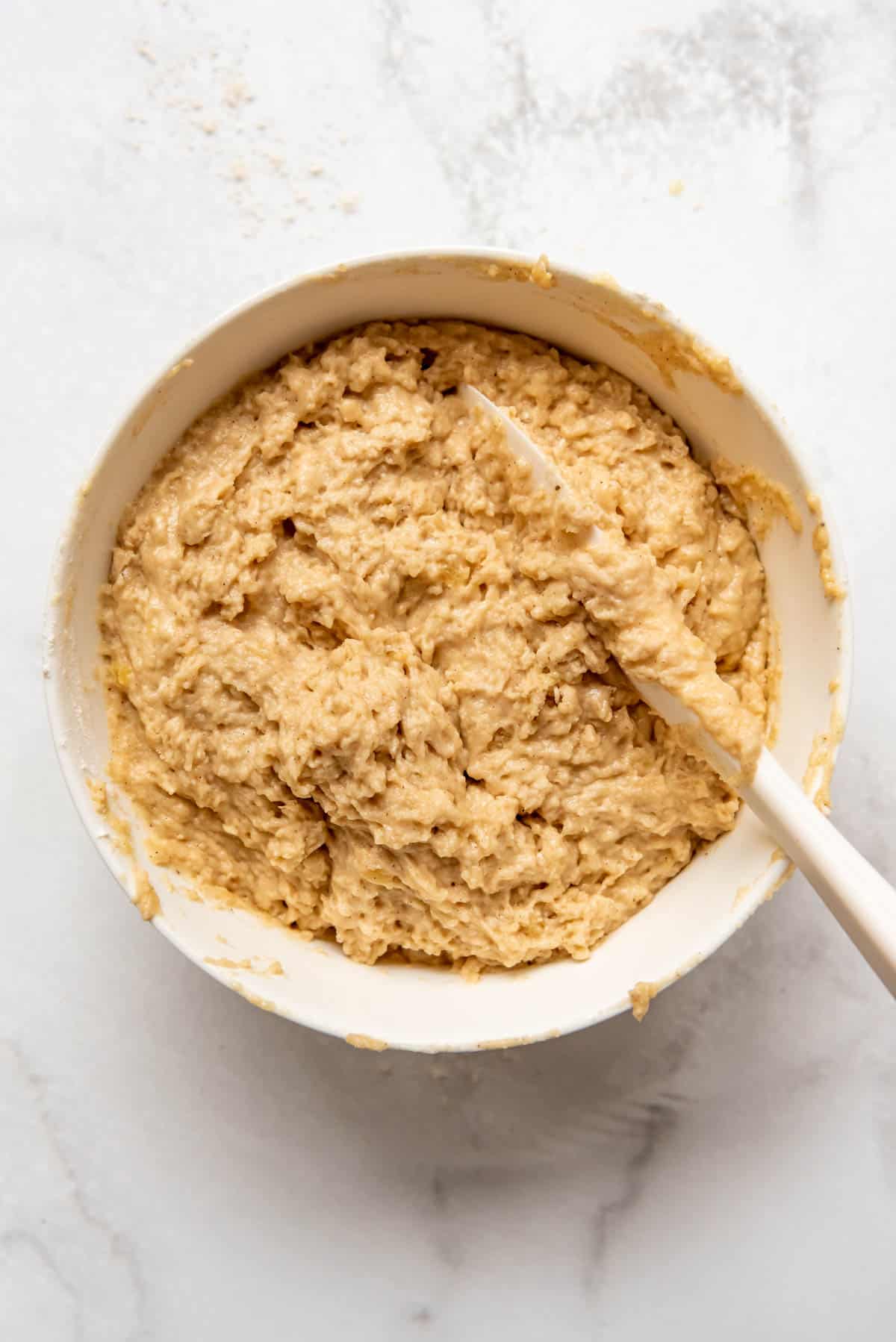 Mixed apple cider doughnut dough in a mixing bowl.