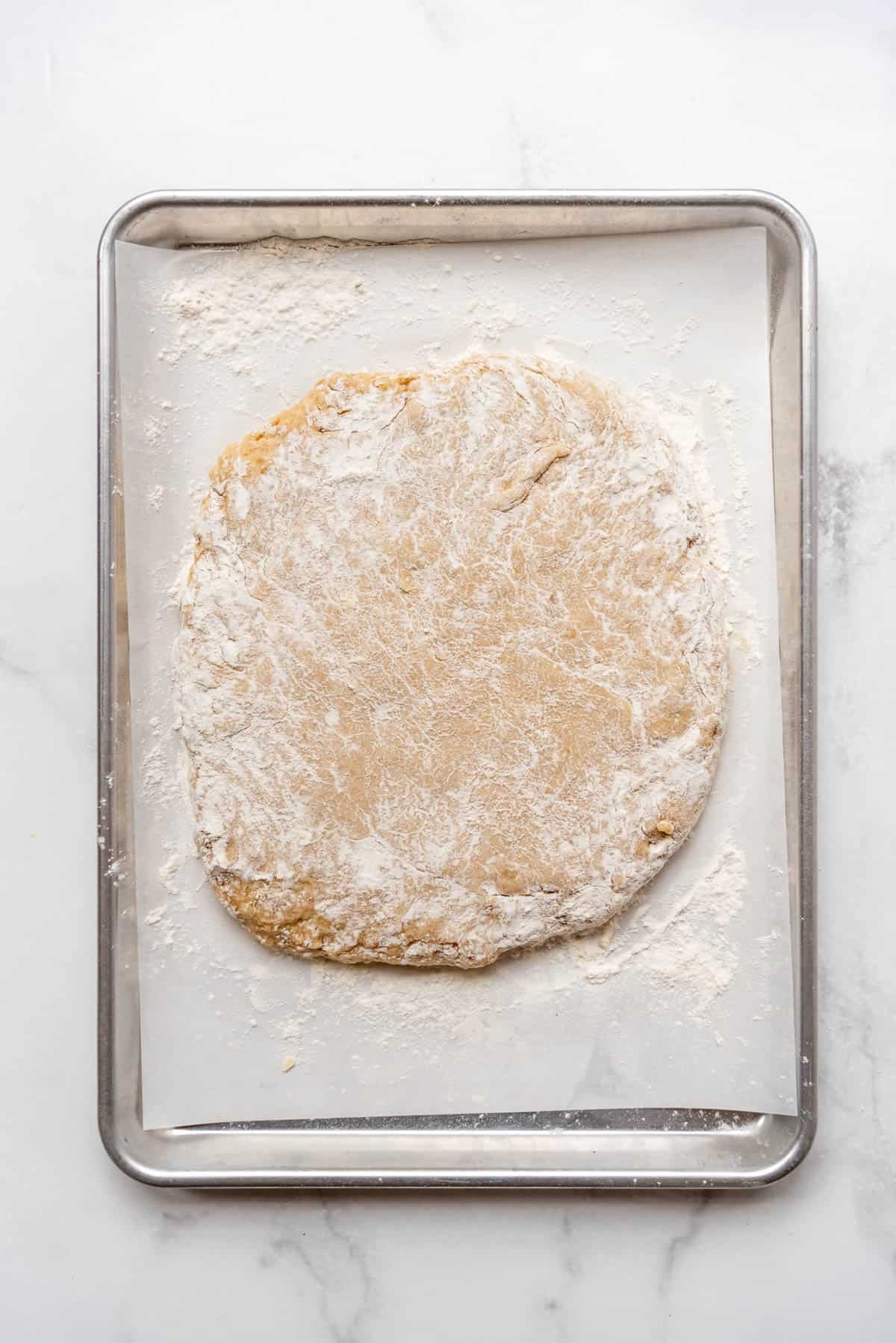 Apple cider donut dough sprinkled with flour and patted  about 1-inch thick.