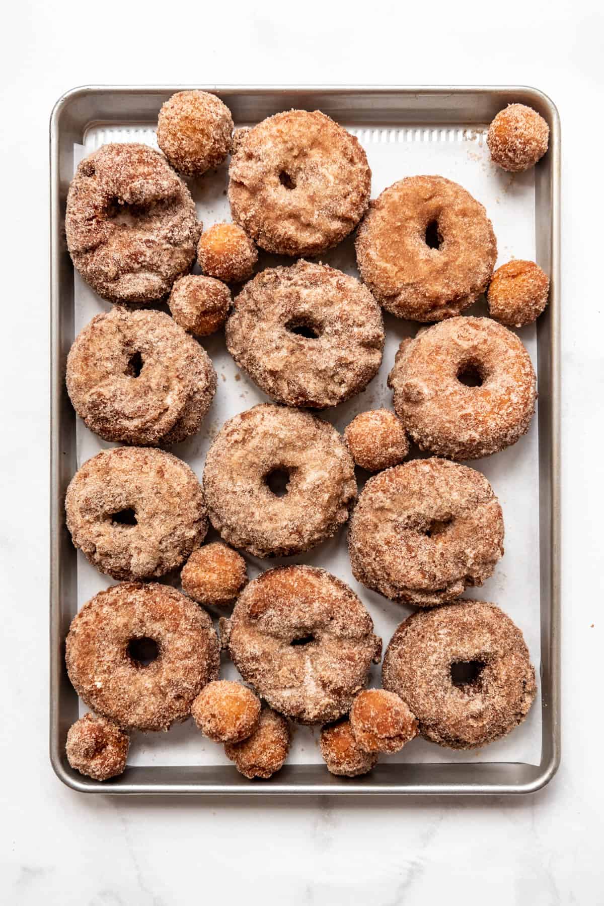 Finished apple cider donuts covered in cinnamon and sugar.