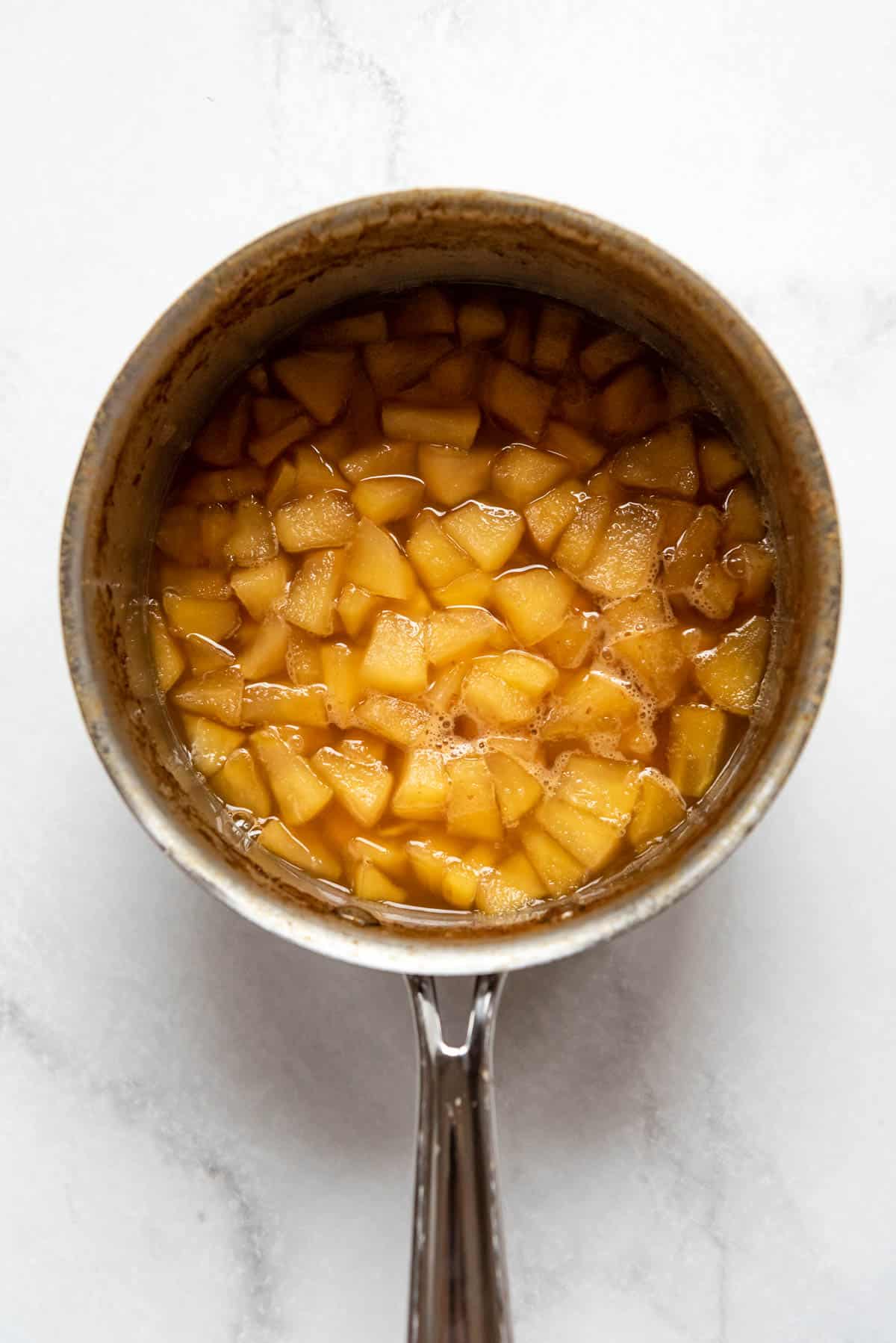 Cooked apples and apple cider after the liquid has reduced.