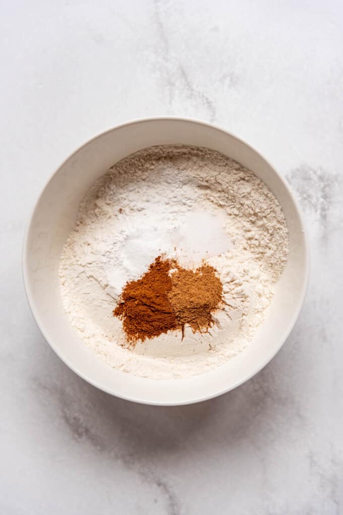 Flour with spices and other ingredients in a large white mixing bowl.