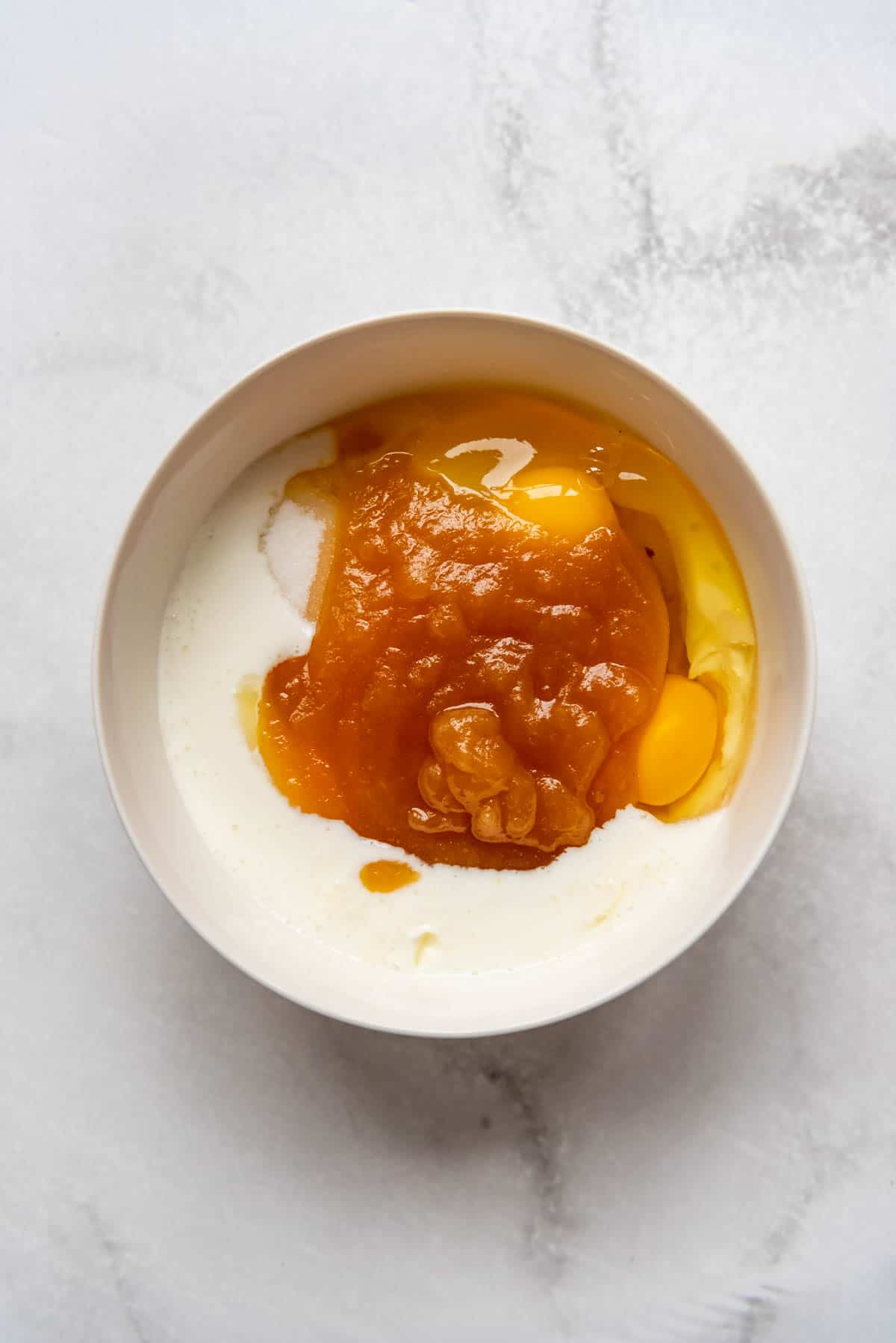 Buttermilk, eggs, sugar, and reduced apples and apple cider puree in a large bowl.