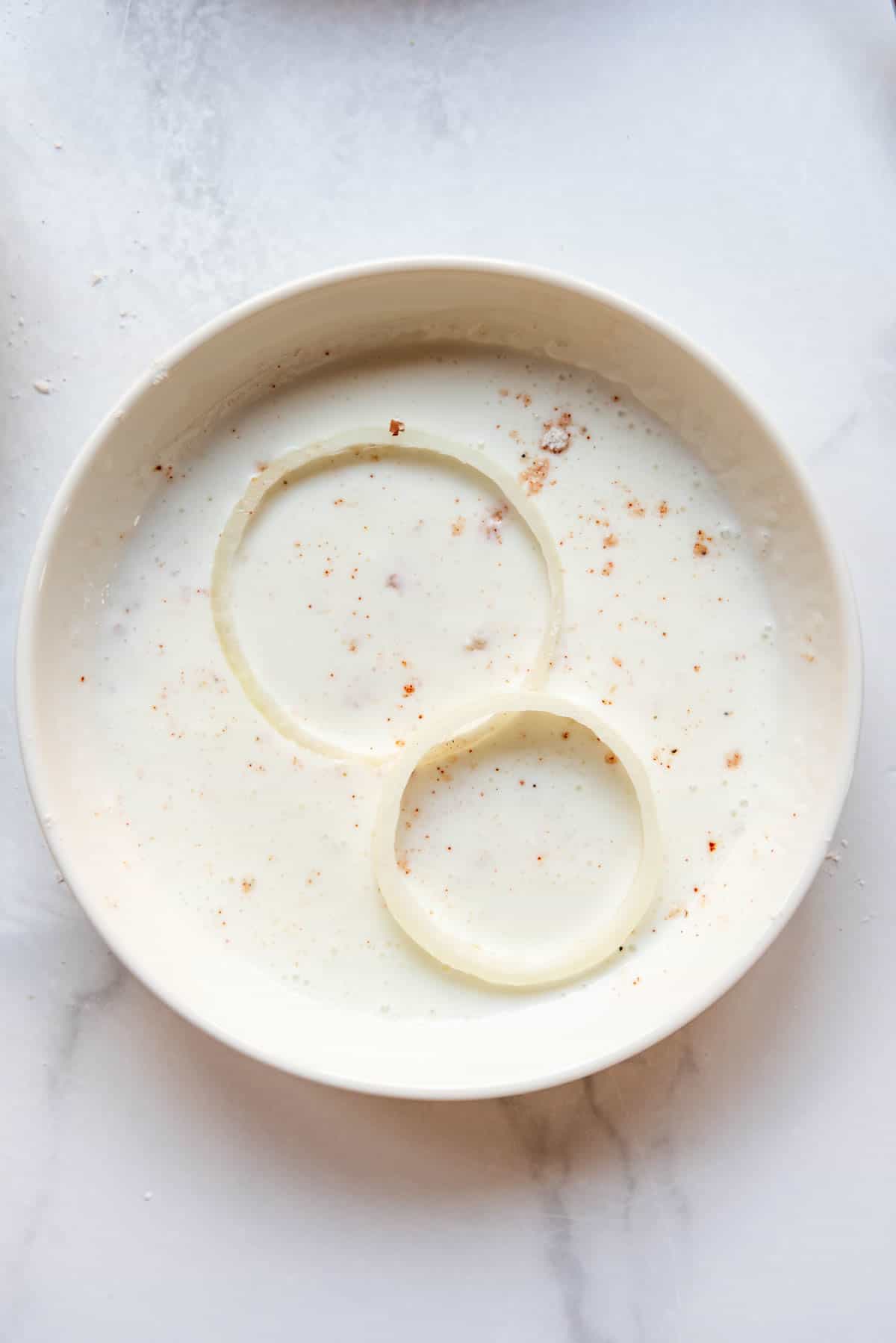 Soaking onion rings in buttermilk.